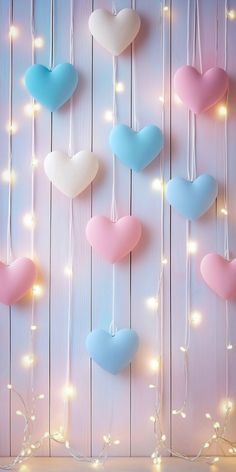 heart shaped balloons hanging from strings against a wooden wall with string lights and fairy lights