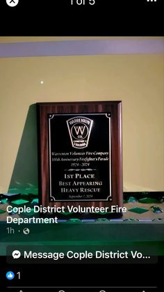 an award plaque sitting on top of a table next to a wall with the words people district volunteer fire department