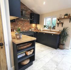 a kitchen with black cabinets and an island in the middle is shown from the doorway