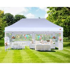 a white tent with tables and chairs in the grass