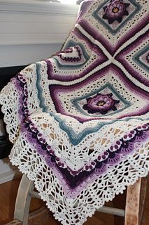 a crocheted blanket sitting on top of a wooden stool