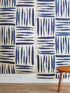 a wooden table sitting in front of a wall with blue and white designs on it