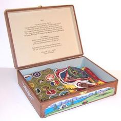 an open suitcase with buttons in it on a white tableclothed surface and a poem written above the lid