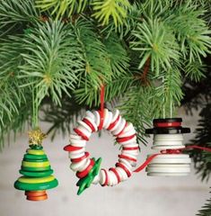 three christmas ornaments hanging from a pine tree