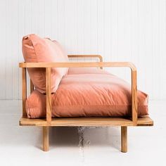 a wooden chair with two pillows on it