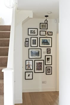 there are many pictures on the wall above the stairs in this house, and it is hard to tell