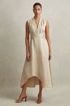 Find REISS Ava Linen Lyocell Strappy Midi Dress on Editorialist. Inspired by a corsetry aesthetic, the Ava midi dress cinches at the waist with adjustable belt straps. It's lustrous linen-lyocell fabric and tactful shoulder pleats maintain a confident look. Linen-lyocell blend. V-Neckline. Pleats to shoulder. Adjustable belt straps. Side pockets. Zip-closure to side. Dipped midi length. The model is wearing a size 8 Chic Spring V-neck Corset Dress, Spring Chic V-neck Corset Dress, Chic V-neck Corset Dress For Spring, Spring V-neck Chic Corset Dress, Fitted Belted Midi Dress For Daywear, Daywear Midi Dress With Natural Waistline, Sleeveless Beige Belted Midi Dress, Sleeveless Dress With Natural Waistline For Daywear, Fitted Midi Dress With Natural Waistline For Spring