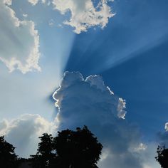 the sun shines through clouds over trees