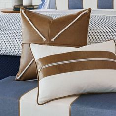 two pillows on a bed with blue and white sheets