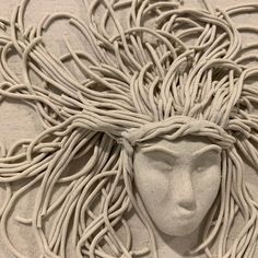 a white sculpture with braids on it's head