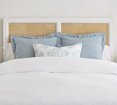 a white bed topped with pillows and blankets