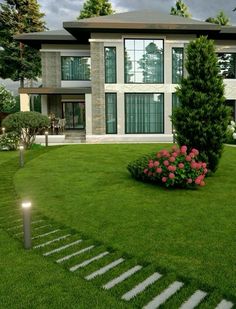 a house with stairs leading up to the front door and landscaping in front of it