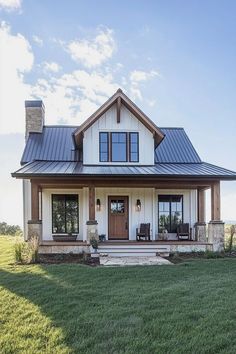 a white and brown house sitting on top of a lush green field