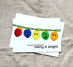 two greeting cards with smiley faces hanging on a string