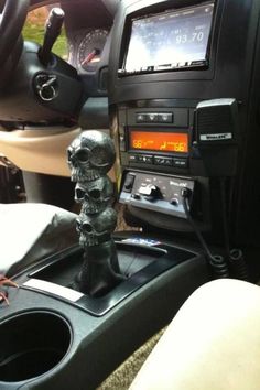 there is a radio in the car with a skull statue on it's dash board