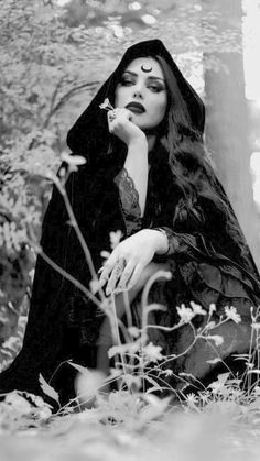 a woman with long hair sitting in the woods