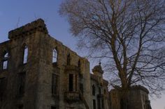 an old abandoned building sitting next to a tree