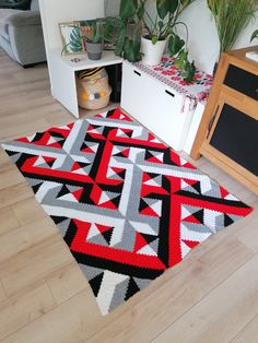 a living room with a rug and potted plants