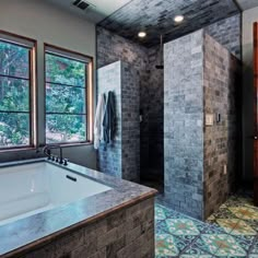 a bathroom with a large bathtub next to a walk in shower and two windows