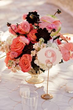 the table is set with pink and white flowers