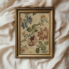 a painting hanging on the side of a bed