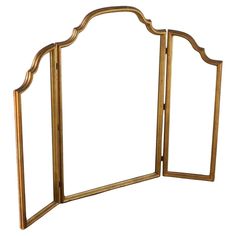 a gold colored folding mirror with an arched design on the front and back sides,