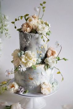 three tiered cake decorated with flowers and greenery