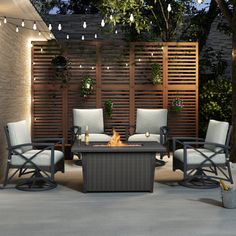 an outdoor seating area with chairs and fire pit in the center, surrounded by wooden privacy screens