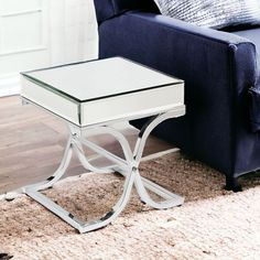 a white table sitting on top of a rug next to a blue couch