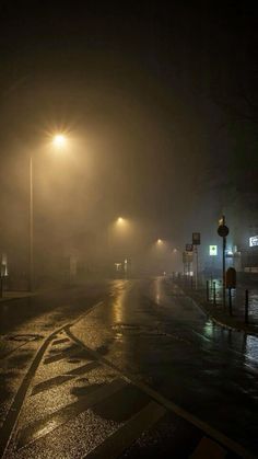 the street lights shine brightly on a foggy night in an area with no traffic