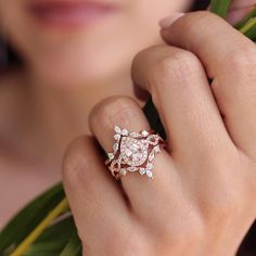 a woman's hand with a ring on it and flowers in front of her