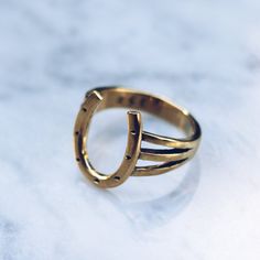 Brass Horseshoe Ring for women or men designed with a minimal band and a western style. The horseshoe has a long history of being a protective symbol and a charm used to protect against any form of evil and bring good luck. Available in 925 Sterling Silver https://etsy.me/2R7Aoj9 Ring Size Available in all sizes. Please be sure to find your exact ring size for the finger you want before ordering. See image chart above or you can use the chart on my website as a guide - https://jewelrylab.co/page Gold Horseshoe Ring, Elegant Yellow Gold Horseshoe Rings, Silver Horseshoe Ring As Gift, Cowboy Ring, Silver Adjustable Horseshoe Rings, Cowgirl Ring, Vintage Gold Horseshoe Jewelry, Cowboy Jewelry, Western Rings