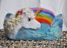 a stuffed unicorn laying on top of a wooden table