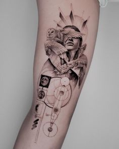 a woman's arm with an owl and clock tattoo on the left side of her leg