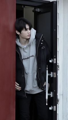 a young man standing in the doorway of a building