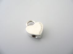 Offered for sale is a wonderful and rare Tiffany & Co. Sterling Silver "Marry Me" Heart padlock pendant / charm. The padlock opens and closes. Super versatile charm that you can add on to any necklace or bracelet ... Perfect item to show off your "Tiffany" style! The piece is simple, elegant, and classic all rolled into one item. It is a wonderful Tiffany piece to start or add to your collection. As always, the item is hallmarked and guaranteed to be 100% authentic.Particulars:The charm is a tad Tiffany And Co Padlock Necklace, Heart Padlocks, Tiffany Style, Heart Love, Marry Me, Necklace Bracelet, Tiffany & Co., Phone Ring, Necklaces Bracelets