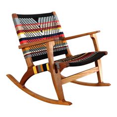 a wooden rocking chair with multicolored fabric on it's seat and back