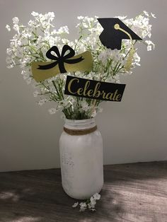 a mason jar filled with flowers and graduation decorations