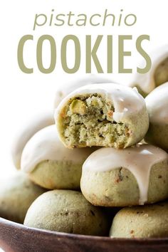 there is a bowl full of cookies with frosting on top and the words pistachio cookies above it