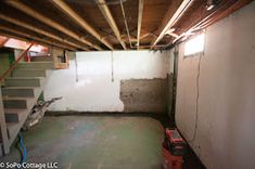 an unfinished basement with stairs and hard wood flooring