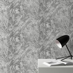 a black lamp sitting on top of a table next to a wallpapered background