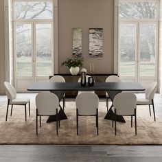 a dining room table with chairs and vases on it in front of large windows