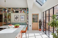 a kitchen with lots of bookshelves and plants