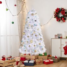 a white christmas tree with presents under it