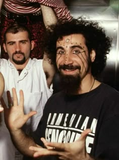 two men with painted faces and beards posing for the camera