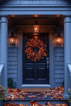 a front door with a wreath and two lights on it