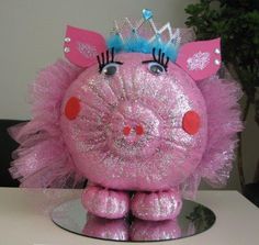 a pink stuffed animal with a tiara on it's head sitting on a table