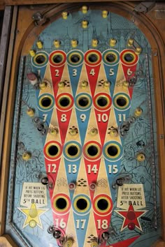 an old fashioned pinball machine with numbers and symbols on it's side,