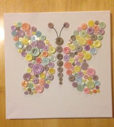 a butterfly made out of buttons sitting on top of a white paper