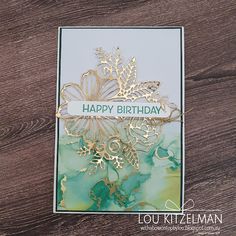 a close up of a birthday card on a wooden table with woodgrain and gold foil